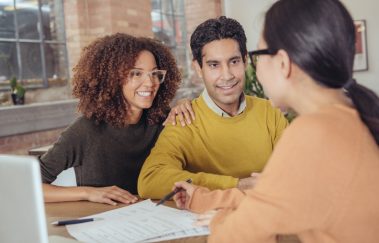 Young couple meeting with real estate professional to close a real estate transaction